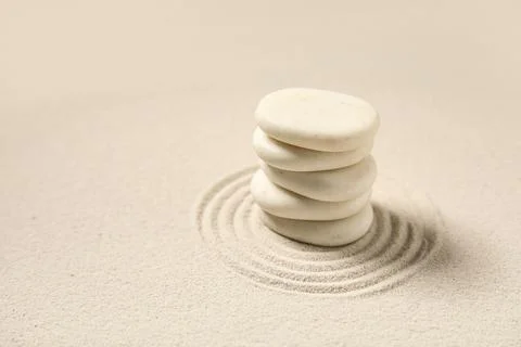 Composition with stack of spa stones and lines on light sand as background, c Stock Photos