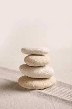 Composition with stack of spa stones and lines on sand as background, closeup Stock Photos