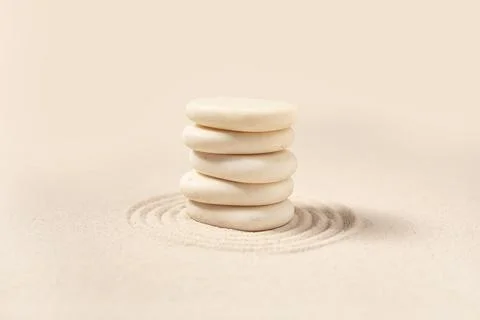 Composition with stack of spa stones and lines on light sand as background, c Stock Photos