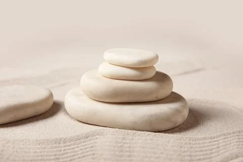 Composition with stack of spa stones and lines on sand as background, closeup Stock Photos