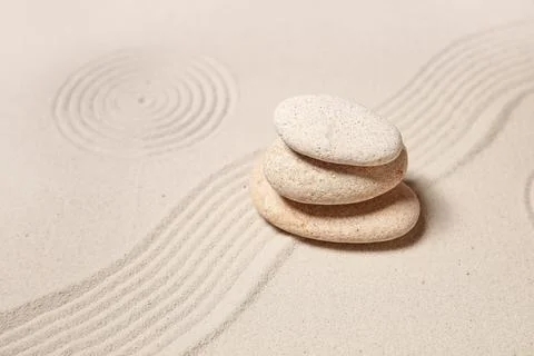 Composition with stack of spa stones and lines on light sand as background, c Stock Photos