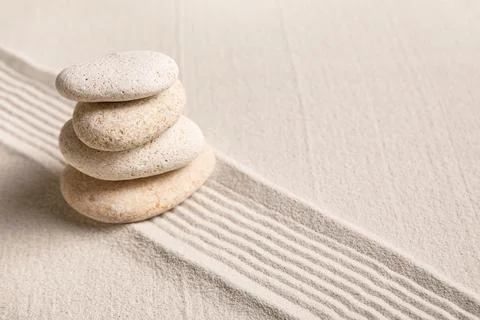 Composition with stack of spa stones and lines on sand as background, closeup Stock Photos