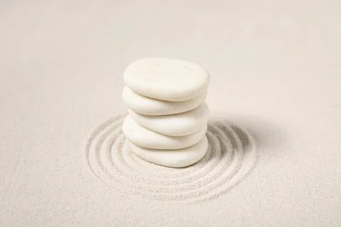 Composition with stack of spa stones and lines on sand as background, closeup Stock Photos