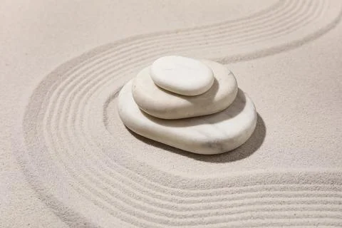 Composition with stack of spa stones and lines on light sand as background, c Stock Photos