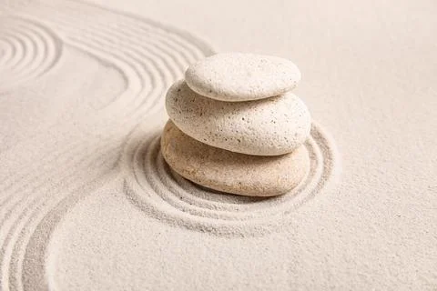 Composition with stack of spa stones and lines on sand as background, closeup Stock Photos