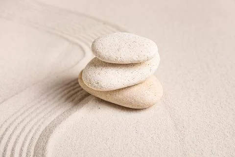 Composition with stack of spa stones and lines on sand as background, closeup Stock Photos