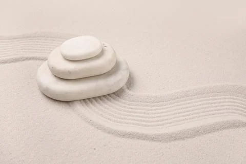 Composition with stack of spa stones and lines on light sand as background, c Stock Photos