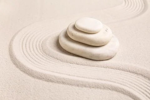 Composition with stack of spa stones and lines on sand as background, closeup Stock Photos