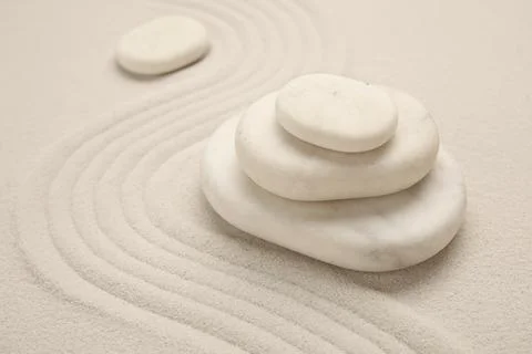 Composition with stack of spa stones and lines on light sand as background, c Stock Photos