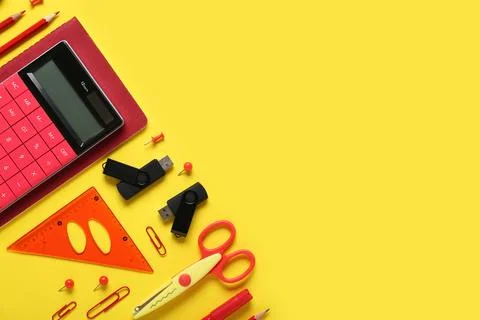 Composition with stationery and modern flash drives on yellow background Foto stock