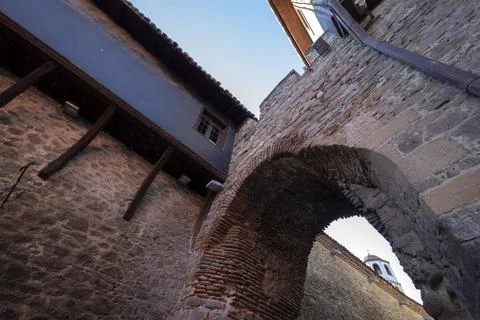 Composition of stone arch and roofs of Revival houses. Stock Photos