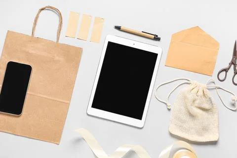 Composition with tablet computer, mobile phone and delivery paper bag on grey Stock Photos