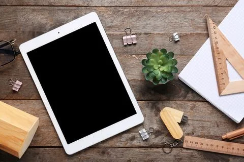 Composition with tablet computer, stationery and modern flash drive on wooden Stock Photos