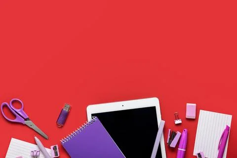 Composition with tablet computer, stationery and modern flash drive on red ba Stock Photos