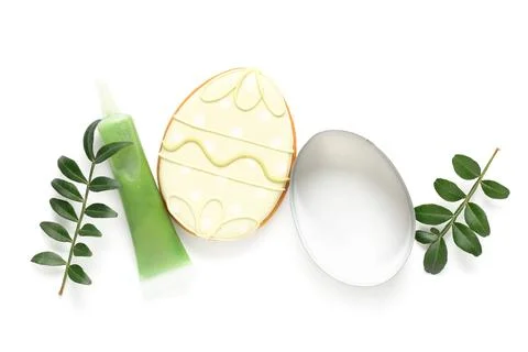 Composition with tasty Easter cookie in shape of egg and green twigs isolated Stock Photos