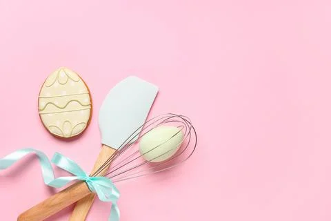 Composition with tasty Easter cookie in shape of egg and kitchen utensils on  Stock Photos