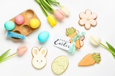 Composition with tasty Easter cookies and tulip flowers on white background Stock Photos