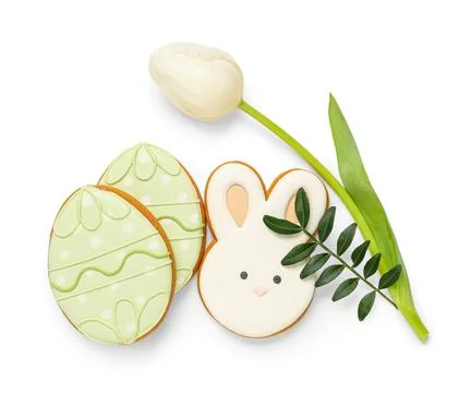 Composition with tasty Easter cookies and tulip flower isolated on white back Stock Photos