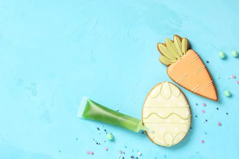 Composition with tasty Easter cookies and sprinkles on blue background Stock Photos