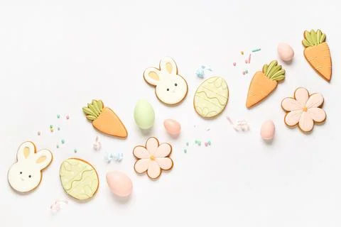 Composition with tasty Easter cookies, eggs and sprinkles on white background Stock Photos