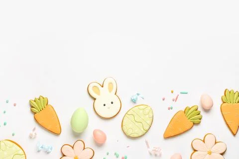 Composition with tasty Easter cookies, eggs and sprinkles on white background Stock Photos