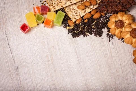 The composition of the tea on a wooden surface. scattering of tea, almond a.. Stock Photos