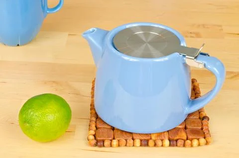 Composition with teapot, cup and lime Stock Photos