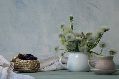 Composition on textured background with dandelions, cup of coffee, dates and Stock Photos