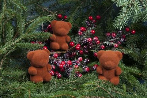 Composition of three bears placed on a holly branch and its red berries Stock Photos