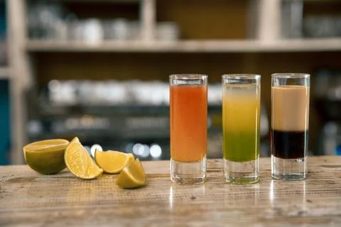 A composition of three colorful shot drinks. Alcoholic cocktails with lime on Stock Photos