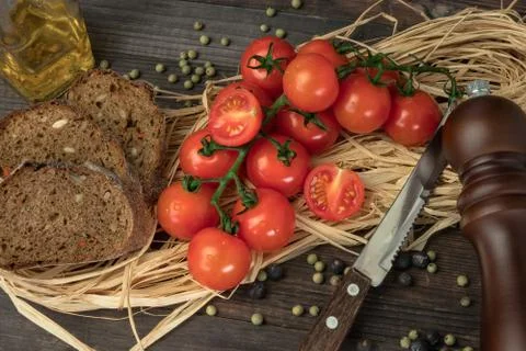 Composition from tomato. Fresh cherry tomatoes on a wooden table with spices. Stock Photos