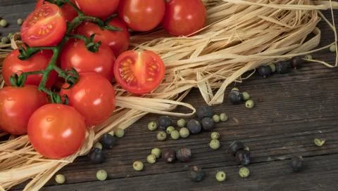 Composition from tomato. Fresh cherry tomatoes on a wooden table with spices. 库存照片