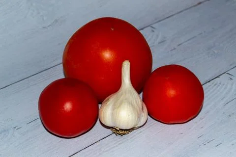 Composition of tomatoes and garlic on the table 스톡 사진