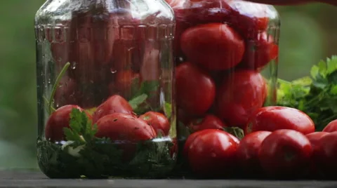 Composition of tomatoes. Hand puts the tomatoes in a jar. Stock-Footage 67009809