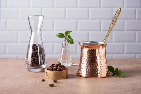 Composition of Turkish cezve, coffee beans and branch of a coffee tree Stock Photos