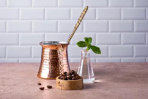 Composition of Turkish cezve, coffee beans and branch of a coffee tree Stock Photos