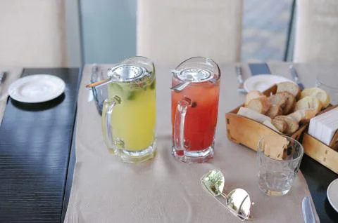Composition of two colorful red and yellow glasses with tea and sunglasses on Foto stock