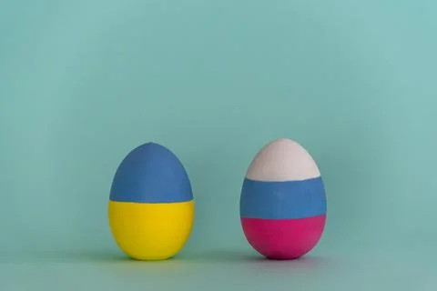 Composition with two Easter eggs colored in colors of Ukraine and Russian flags Stock Photos