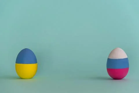 Composition with two Easter eggs colored in colors of Ukraine and Russian flags 库存照片