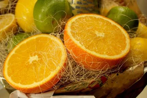 Composition of two halves of oranges, green limes and yellow lemons in the ba Stock Photos