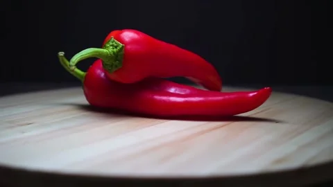Composition of two red peppers. Rotation on a dark background. Video stock 169625579