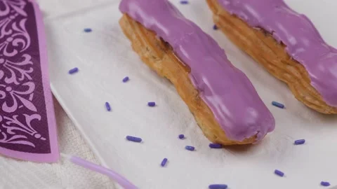 Composition of two rotating eclair cakes in trendy colors 2022 Very Peri Stock Footage 167331878