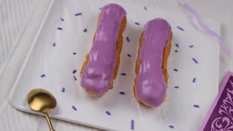 Composition of two rotating eclair cakes in trendy colors 2022 Very Peri Stock Footage 167331895