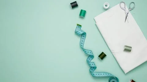 Composition with various threads and sewing accessories on green background.  Stock Photos