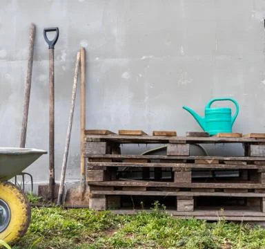 Composition. vegetable garden. working tools, cart, pallets and watering can Stock Photos