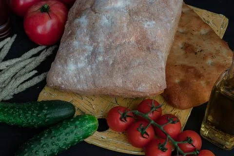 A composition of vegetables and bread in a rustic style on a black wooden tab Stock Photos