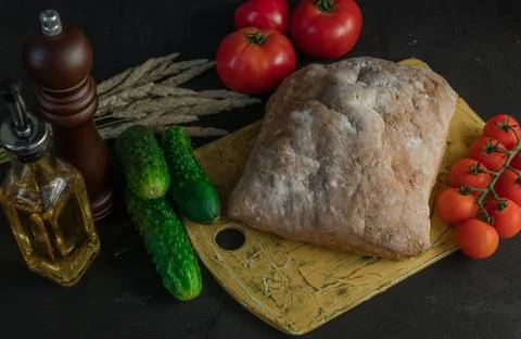 A composition of vegetables and bread in a rustic style on a black wooden tab Stock Photos