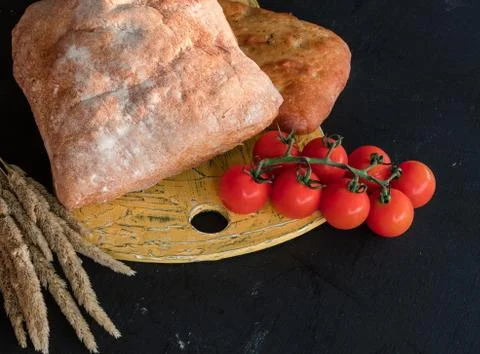 A composition of vegetables and bread in a rustic style on a black wooden tab Stock Photos