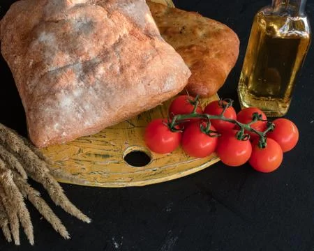 A composition of vegetables and bread in a rustic style on a black wooden tab Stock Photos