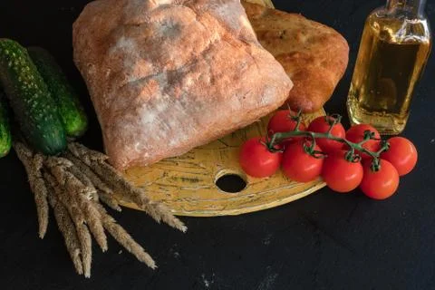 A composition of vegetables and bread in a rustic style on a black wooden tab Foto stock